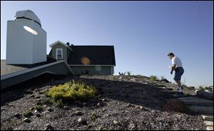 Ralph Semrock, whose goal is energy self-reliance, mounts the earth-bermed rear of his home. 