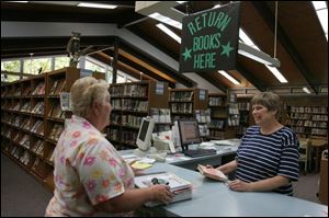 Jane Kohlenberg, right, director of the Pemberville Public Library, discusses library services with Diane Henry.