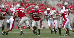 Ohio State offensive linemen Rob Sims (77) and T.J. Downing (72) clear the way for running back Antonio Pittman (25).