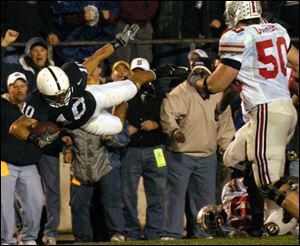 Penn State safety Calvin Lowry flies out of bounds after being tackled by Ohio State quarterback Troy Smith (on ground). Lowry had intercepted one of Smith's passes.