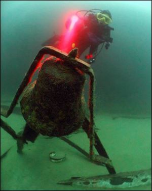 A diver takes a close look at the bell of the Sadie Thompson, a barge which sank in 116 feet of Lake Superior water near Whitefish Point in a storm in the early 1950's. 