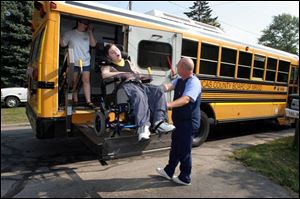 Jim Brockman, one of about 150 employees of CareLink Nursing Services, helps Matthew Reynolds off the bus.