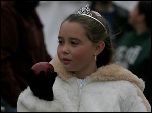 Twelve-year-old Brooke Hensley, who was runner-up in the royalty contest at the festival, takes time from royal duties to try an apple.