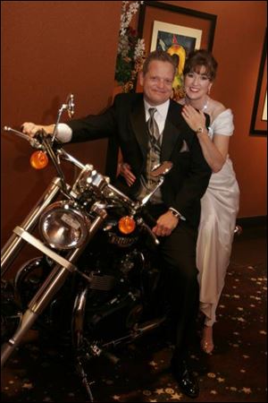 HIGH-POWERED COUPLE: Tony Shula poses with the 2005 Triumph Speedmaster as his wife, co-chairman Paulette Roberts Shula, admires the scene.