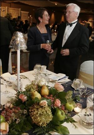 STAGE SETTING: Karen and Carlton Fraker chat during the elegant event. The table was set with silver and crystal, and the floral arrangements were admired.