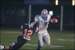 Elmwood's Al Tyson stiff-arms Otsego's Jason Asmus in last night's Suburban Lakes League overtime battle. Elmwood plays at Woodmore next and ends with Eastwood at home. 