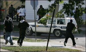 Demonstrators pelt a Toledo Police sport utility vehicle with rocks at Mulberry Street and Central Avenue in Toledo.