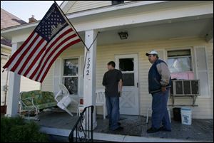 John Szych, right, surveys damage at his Bronson Avenue home after protesters went past. He said he has had no contact with a neo-Nazi group that was a focus of the angry mob.