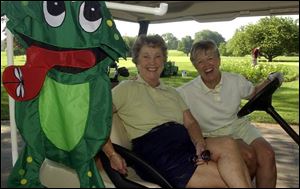 THREESOME? Lou Woellner and Jan Merki have some company in their golf cart at Highland Meadows.