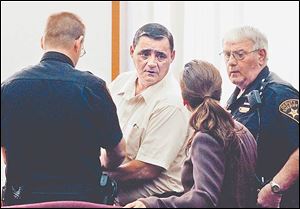 Paul Efaw speaks to his lawyer as he is handcuffed after his sentencing in Huron County Court. He was convicted for killing Connre Dixon during an argument in October, 2004.