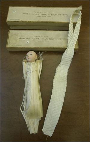 A doll and a tie are souvenirs from the Chicago World's Fair. 