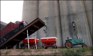 A farmer pulls away after dumping his load of corn at a grain elevator in Custar, Ohio. associated press Corn waits to be stored in a grain elevator in Custar, Ohio.