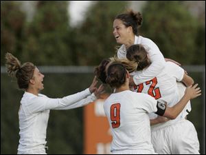 Bowling Green State University s Julie Trundle is mobbed by teammates after she made the winning kick against Toledo. It was the senior s third successful penalty kick this season.
