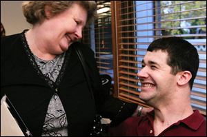 Patricia Corrigan laughs with her former student, Matthew Drake, at a homecoming party in Sylvania. Mr. Drake was badly hurt by a suicide car bomb in Iraq in October, 2004.