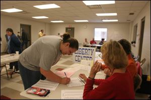 Brandi Lingruen of Liberty Center, Ohio, signs in to vote yesterday afternoon at the Liberty Center Fire Station. Among issues facing Henry County voters was a sales tax repeal, which they overwhelmingly supported.