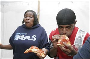 Rashidah Richardson gets ready to down the next slice of pizza as Stevie Crumby works on a slice during the pizza eating challenge at Vito's. Both lost to Lakota the bear.