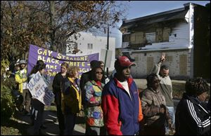 Prayer marchers walk down Mulberry after stopping to pray at Jim & Lou's bar, which was burned in the Oct. 15 riot.