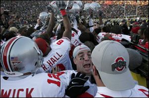 Ohio State football players celebrate with their fans after yesterday's last-minute victory against the University of Michigan in Ann Arbor.