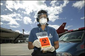 Belinda Lee holds a specimen bag that Hawaii uses to check ill airline passengers for bird flu. Hawaii is the first state to test.