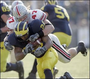 Ohio State linebacker A.J. Hawk smothers Michigan running back Mike Hart for a loss in the first quarter at Michigan Stadium. Hawk had seven tackles, giving him 382 for his four-year career. Hart was held to 15 yards rushing on nine carries.