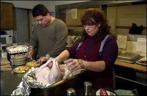 Virgil and Teri Garcia prepare a Thanksgiving meal in 2002 for patrons of the Good Samaritan Outreach Center. Despite Mr. Garcia's death, the tables will still be set this holiday.