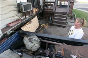 Jeannie Herrick helps clean up damage from a fire caused by a turkey fryer Nov. 12 at her mother's house in East Toledo.