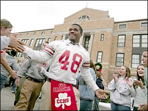 Slug: CTY central02p             Date:   12.02.05        The Blade/Madalyn Ruggiero      Location:  Central Catholic, Toledo, o  Caption:     Central Catholic football player AaronPeterson a junior   at   is mobbed by students while heading to the bus at Central Catholic Friday morning 12.2.05 just before heading to Division  11 finals tonight.