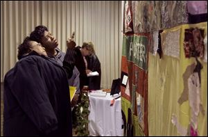 Pearline Kemp, left, and Lena McClain look at an AIDS memorial quilt in the Franciscan Center at Lourdes College.