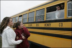 Brittany Merritt, left, and Meagan Buenger wish Patrick Henry football players good luck as the team departs for the Division V football title game today in Canton. It is the first championship game in school history.
