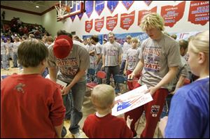 Wide receiver Marc Krauss, left, and quarterback Zack George sign autographs for their fans after a celebration at Patrick Henry High School in Hamler, Ohio.