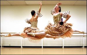 Lucy Messervy, front, and Ariel Warrick glide gracefully through the air in a scene from <i>The Nutcracker</i>.