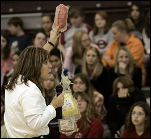 Terri Shinn fills in seventh graders at John C. Roberts Middle School on the details of blood donation. Most students were relieved to be asked to recruit donors, not become ones.