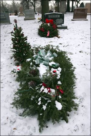 Evergreen grave blankets decorate graves in Calvary Cemetery in Toledo.
