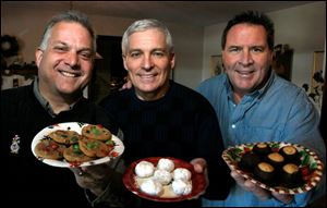 Joe Pasquinelli, left, Dave Kaminski, and host Lad Norris, friends who grew up together, show off the cookies and candy each made for their annual cookie party.