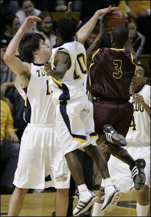 Toledo's Allan Pinson, left, blocks a shot by Ferris State's Dennis Springs, right. Kashif Payne (10) is also in the play.