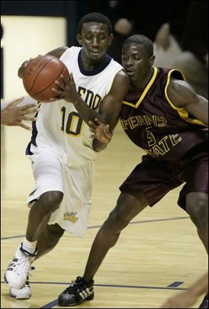 Kashif Payne of the Rockets drives against Dennis Springs of Ferris State in first-half action at Toledo's Savage Hall.