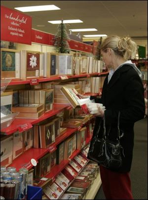 Vicki Lennex, of Lambertville, makes a selection at Carol's Hallmark in Bedford Township, where sales of boxed Yule cards have declined.