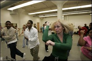 Dance instructor Deb Calabrese conducts a session at Toledo School for the Arts with alumnus Terry Snipes, at left, and Clarence Nedd. The school is on 13th Street, near downtown Toledo.