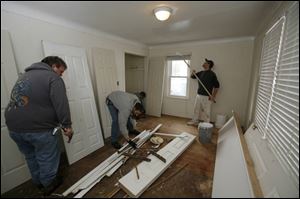 From left, Chuck Bennett, Bob Gerber, and Ed Matuszynski tackle a bedroom of a 'distressed' house owned by Juscot Realty. 