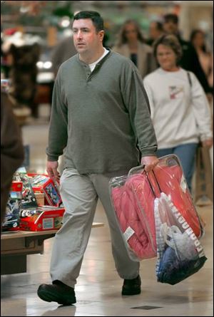 Tim Menard of West Toledo does last-minute shopping at Westfield Franklin Park. Many shoppers yesterday were men.