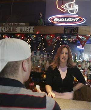 Christine Rutkowski, who has been tending bar for 14 years, chats with a patron at Rookies Sports Bar & Grill. Ms. Rutkowski says she's ready to fend off that first after-midnight kiss.