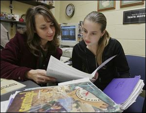 Woodward High School counselor Sarah Barman examines an honors application with senior Kateryna Gololobova.
