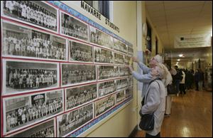 Norma (Sherer) Carsten and her husband, Robert Carsten, look for their class photos from when they were both students at Navarre School in East Toledo. The pair toured the school yesterday during its 85th anniversary celebration. The school is scheduled to be closed and demolished on Jan. 20 to make way for a modern structure as part of a districtwide rebuilding program.