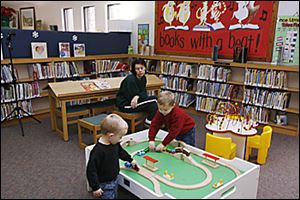 Teresa Reckner of Swanton watches grandsons Logan, 2, and Levi, 4, use the library's facilities. 