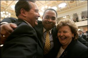 Republican gubernatorial candidates Jim Petro, left, and Kenneth J. Blackwell, and former candidate Betty Montgomery hold a 'group hug,' as suggested by Mr. Blackwell, before the address.