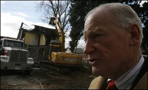 While a demolition crew razes the house at 1627 Pinewood Ave., Mayor Carty Finkbeiner says his goal for 2006 is to tear down 300 abandoned or neglected houses in Toledo.
