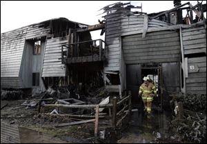 Springfield Township Fire Chief Barry Cousino surveys the damage at the Hidden Cedars Condominium complex.
