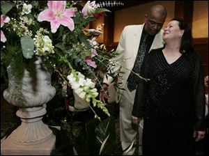 SAY IT WITH FLOWERS: Bruce Mason and his sweetheart, Rhonda Mrock-Parks, admire the towering flowers at the Toledo Club.