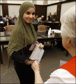 Rana Ahmad Jomaa Saleh, formerly of Lebanon, becomes a U. S. citizen with 67 other people from more than 30 countries during a ceremony in U.S. District Court in Toledo.