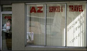 Justin Covyaw, manager of AZ Services & Travel, in the doorway of the business, said customers do not want to visit the office.